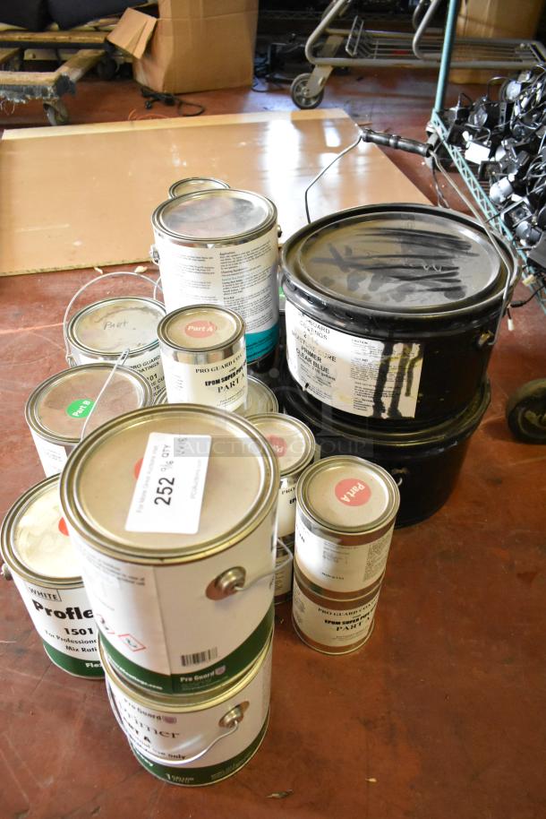 18 cans of Pro Guard chemicals including epoxy and liquid rubber. Labels show Part A/B, clear blue, moisture cure. Auction lot 252.