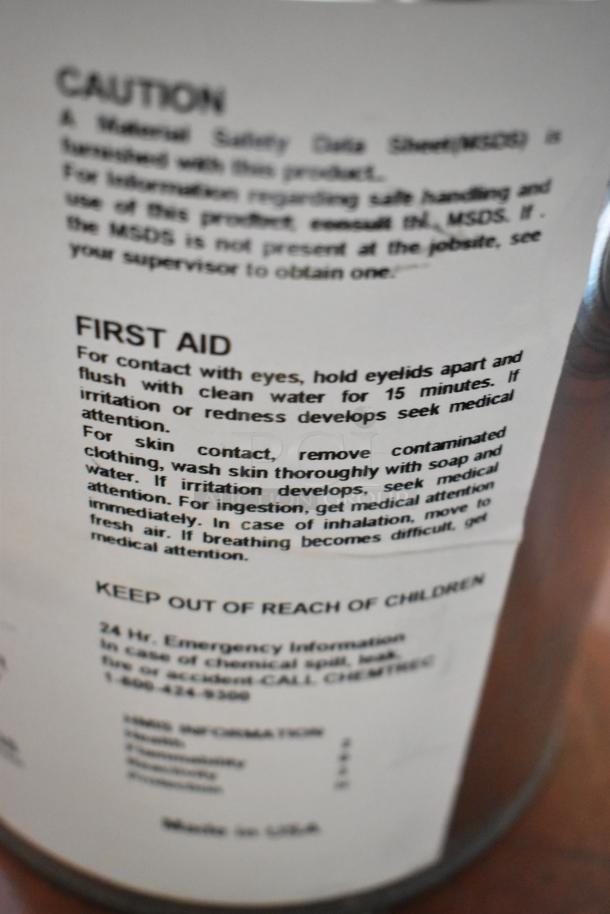 Label on chemical container showing caution and first aid instructions for Pro Guard chemicals, including emergency contact details.