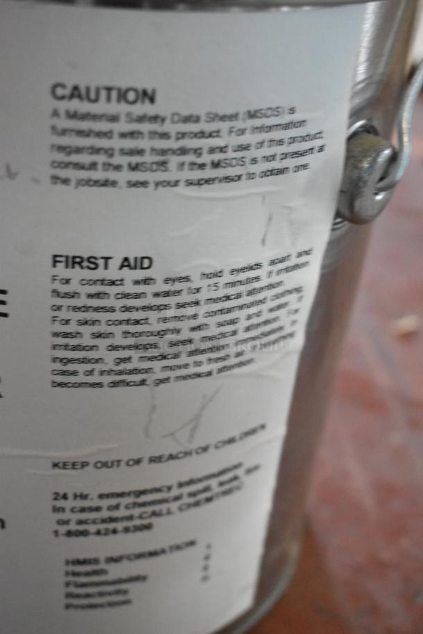 Label on a chemical container with safety instructions, first aid information, and emergency contact details.