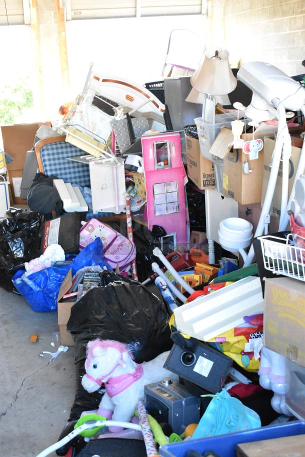 Storage unit contents with stroller, children's furniture, toys, vintage-style popcorn cart, Everlast punching bag, tire, rocking chair, lawnmower.