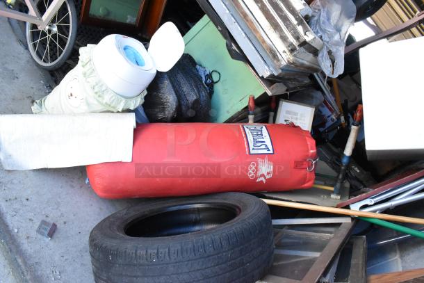 Storage unit contents including Everlast punching bag, stroller, popcorn cart, tire, rocking chair, and lawnmower.
