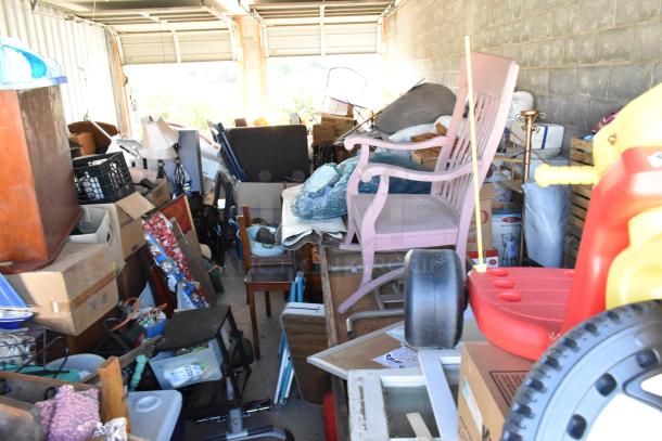 Contents of storage unit #77 including stroller, children's furniture, vintage popcorn cart, Everlast punching bag, tire, rocking chair, lawnmower.