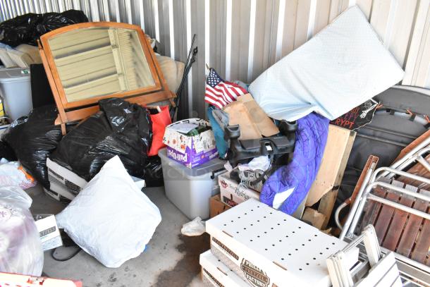 Storage unit #77 contents include a stroller, children's furniture, vintage-style popcorn cart, Everlast punching bag, tire, rocking chair, and lawnmower. Various household items are visible.