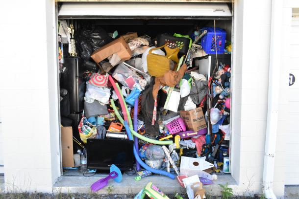 Storage unit contents including mini cooler, Sony TV, children's toys, and baskets. Requires cleaning deposit refund.