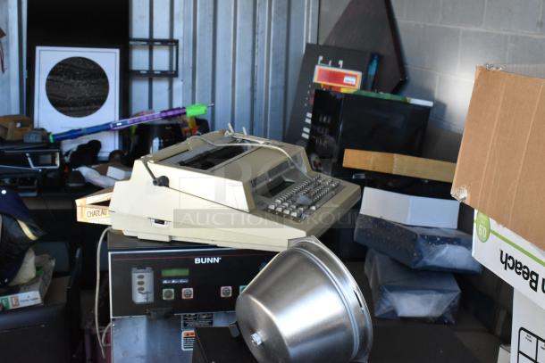 Storage unit #60 contents: Bunn coffee machine, typewriter, cardboard boxes, metal container. Various household items.