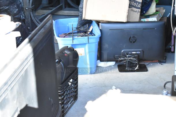 Storage unit contents including an HP monitor, black crate with a portable grill, and a blue bin with miscellaneous items.