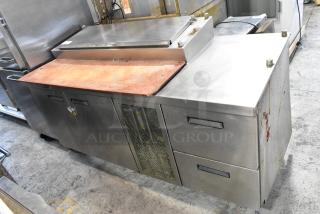 Delfield MKV9885751 stainless steel commercial pizza prep table with oversized cutting board, 2 doors, and 2 drawers.