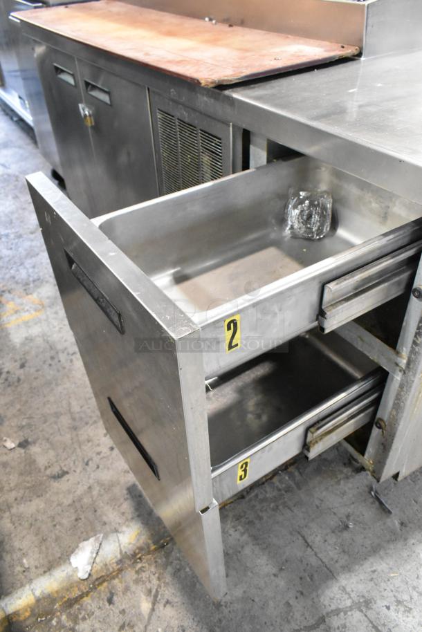 Delfield MKV9885751 stainless steel pizza prep table with oversized cutting board, two doors, and two numbered drawers.
