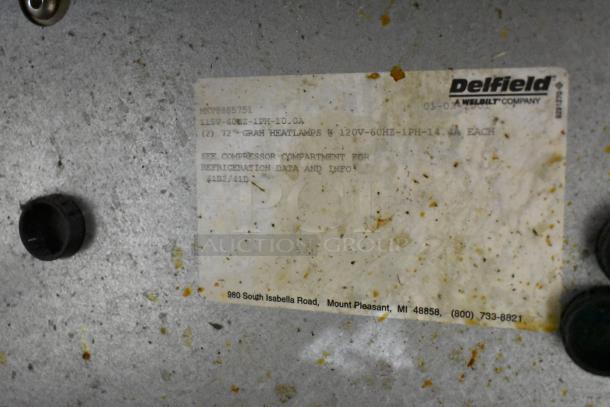 Delfield MKV9885751 stainless steel pizza prep table label showing model, voltage, and company details.