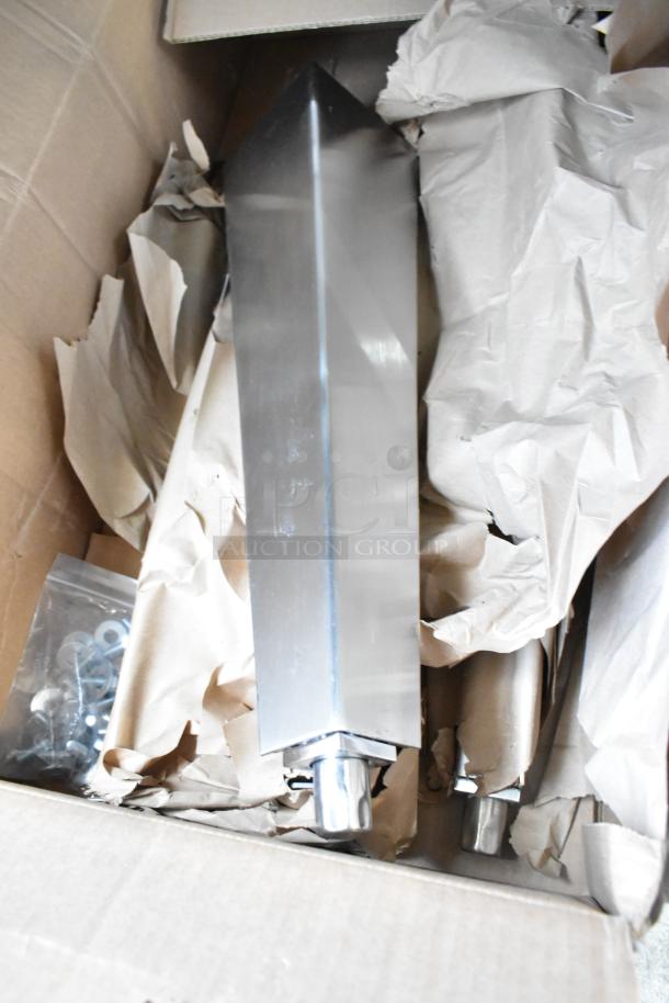 Box of brand new metal legs, model 1951204-0003, for convection oven. Includes hardware, wrapped in paper for protection.