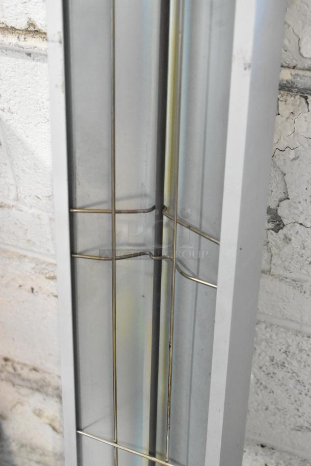 Winco ESH-60 metal heat strip warmer, 120 volts, 1 phase, shown in close-up view, mounted on brick wall.