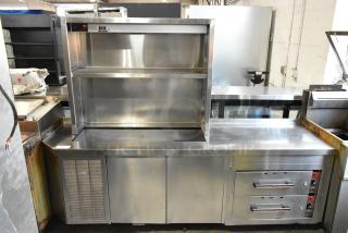 Stainless steel work station with Delfield 8146N 2 door cooler, 2 drawer warming drawers, overshelf and Hatco food strip warmer.