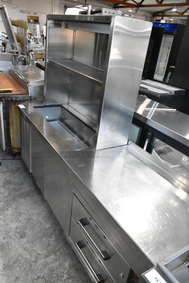 Stainless steel work station with Delfield 8146N cooler, two warming drawers, overshelf, and Hatco food strip warmer.