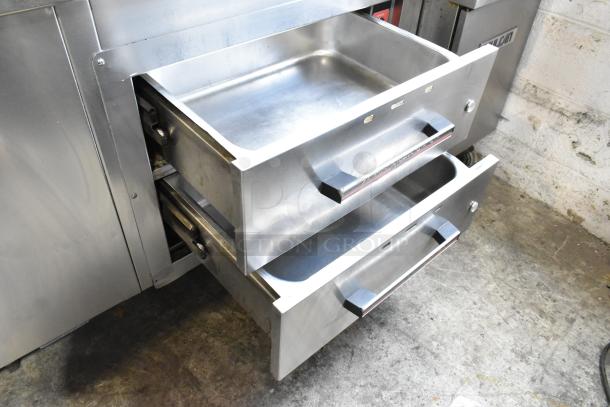 Stainless steel work station with Delfield 8146N cooler, two warming drawers, overshelf, and Hatco food strip warmer.