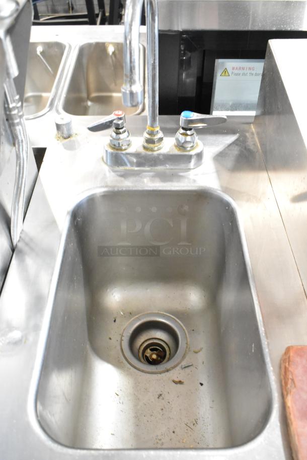 Delfield stainless steel commercial pizza prep table with sink bay, features durable construction and dual faucets.