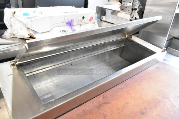 Delfield stainless steel commercial pizza prep table with sink bay, open lid view; features sturdy construction.