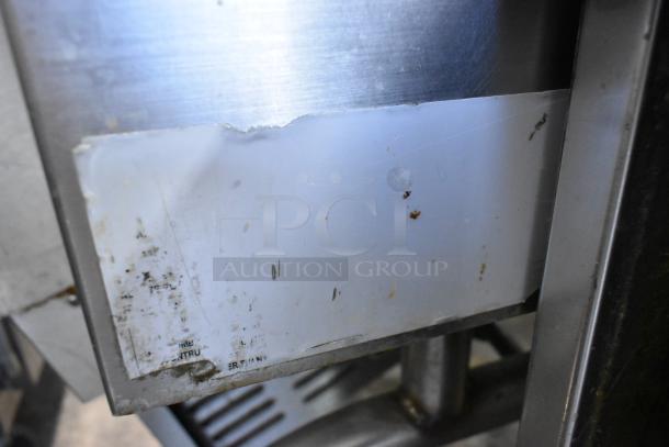 Cleveland stainless steel tilting braising pan on commercial casters, featuring visible wear and markings on the surface.