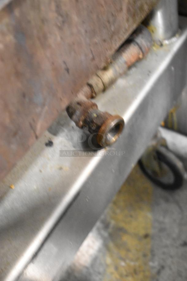Cleveland stainless steel tilting braising pan on commercial casters, showing detailed piping and caster wheel, used condition.