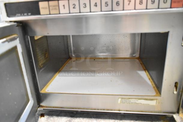 Panasonic stainless steel commercial countertop microwave oven, interior view, showing keypad and slight signs of use.