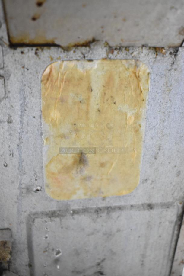 Worn label on a metal surface, unclear text, likely part of the Panasonic stainless steel microwave. Condition suggests wear and age.