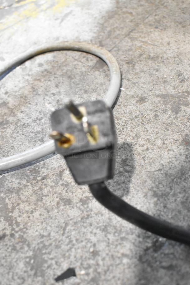 Close-up of a power plug on a Panasonic Stainless Steel Commercial Countertop Microwave Oven.
