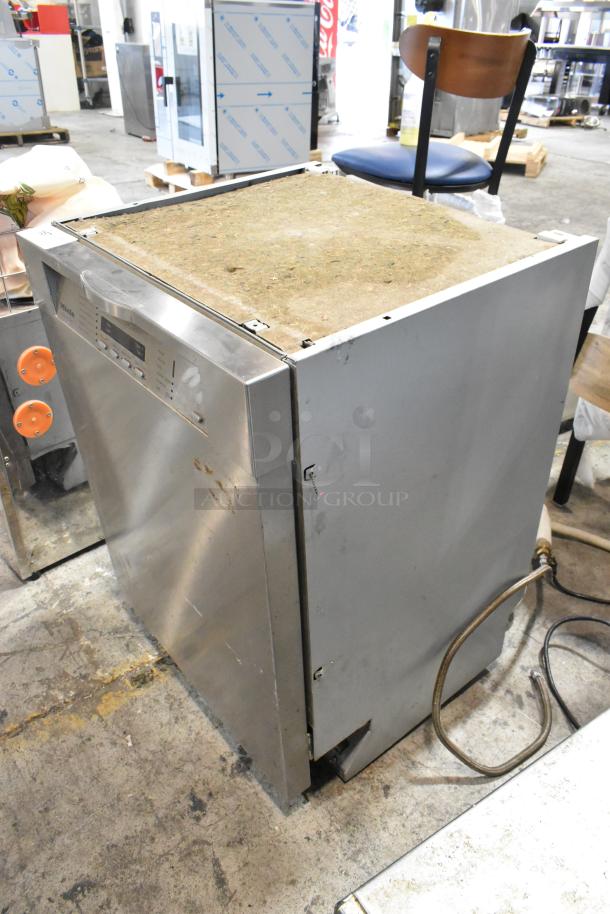 Miele G2432SCU stainless steel undercounter dishwasher, 115V, shows usage wear, visible control panel, industrial setting.