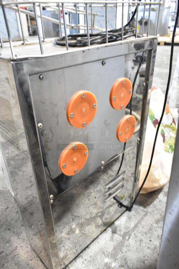 Metal commercial countertop citrus juicer with orange components, 115 volts, 1 phase. Includes spare parts.