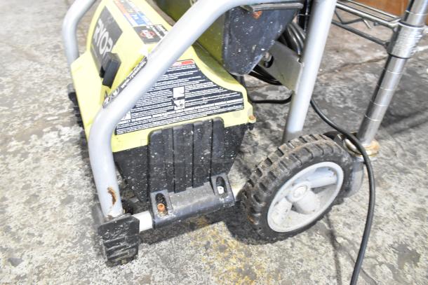 Ryobi 1700 PSI 1.2 GPM Electric Pressure Washer, rust on frame, visible label, sturdy wheels for mobility.