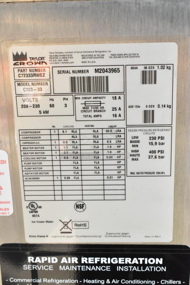 Stainless steel Taylor C723-33 soft serve machine, 2-flavor twist, commercial casters, 208-230V, water-cooled, specs label shown.