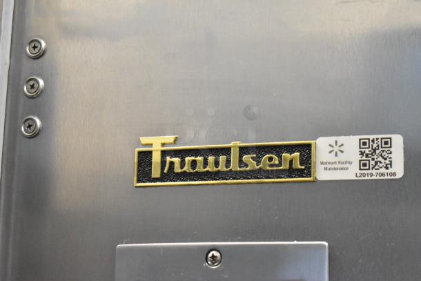 Stainless steel Traulsen TBC13 blast chiller logo, shows metal surface and maintenance tag with QR code.