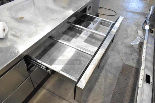 Turbo Air stainless steel 4-drawer chef base on commercial casters, 115 volts, 1 phase, shown with open drawers.