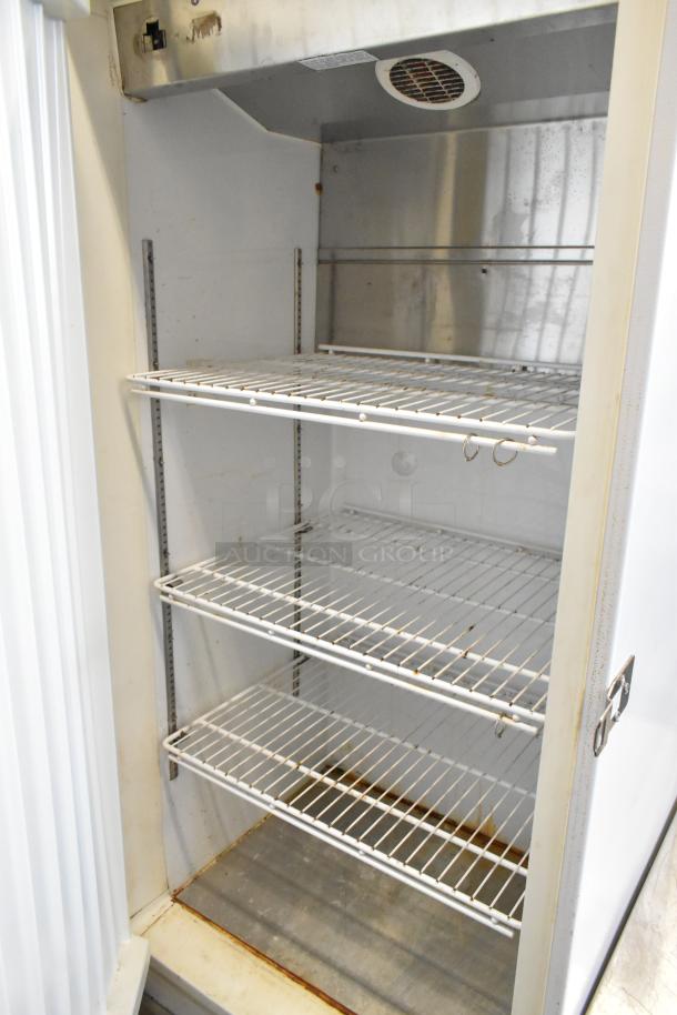 Arctic Air commercial single door reach-in freezer on casters. Visible shelving, signs of wear, 115 volts, 1 phase.