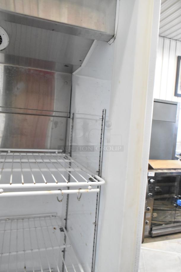 Arctic Air metal commercial single door reach-in freezer with wire shelves and visible metal interior. 115 volts, 1 phase.