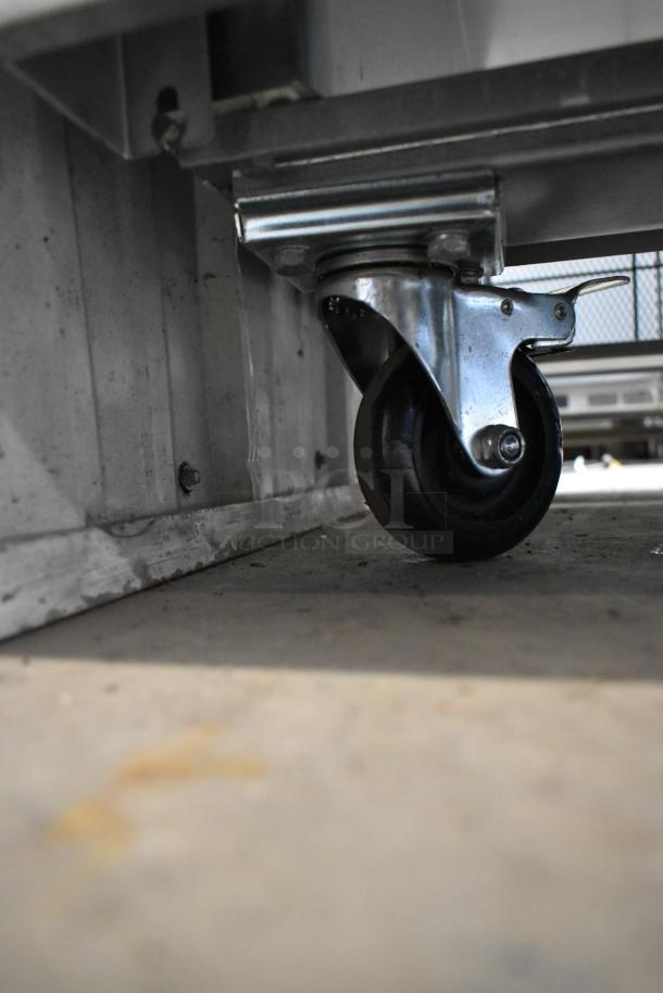 Arctic Air AR49EZ commercial cooler wheel detail, showing durable caster for easy mobility. Stainless steel construction.