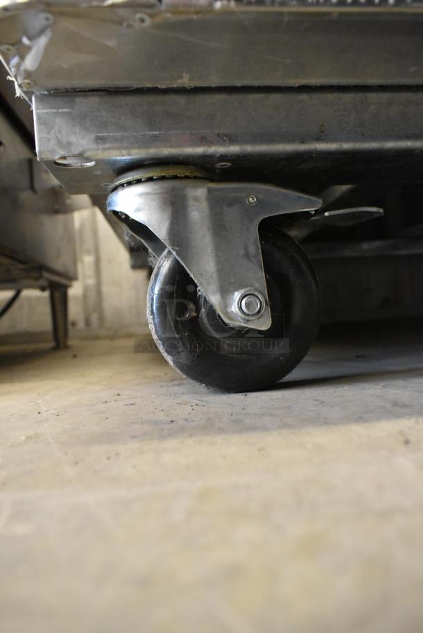 Close-up of the caster wheel on a 2016 Atosa MCF8707 Stainless Steel Commercial 2 Door Cooler.