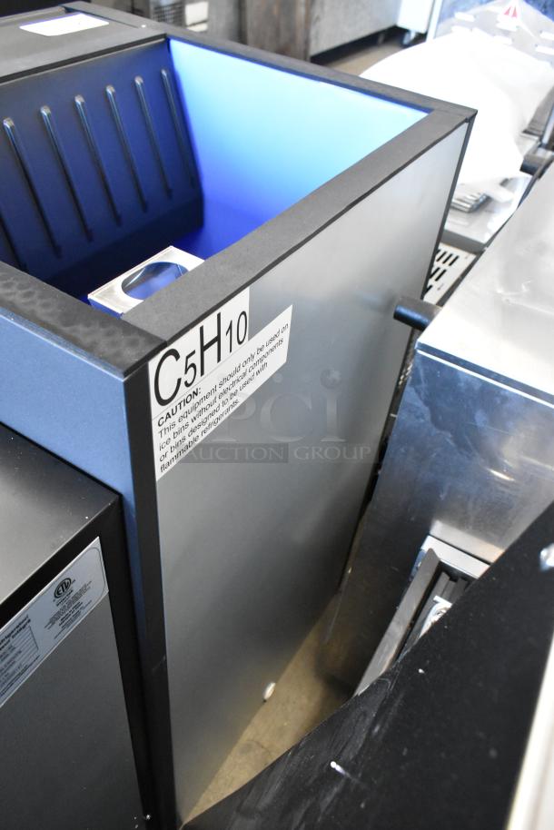 Brand new metal commercial ice bin, scratch and dent, with caution label "C5H10" indicating use conditions.