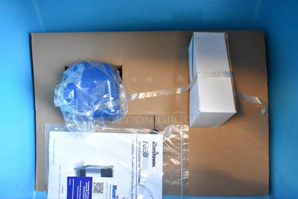 Box contents for Manitowoc UYF0190A-161B ice machine. Includes manual and components, wrapped in plastic packaging.