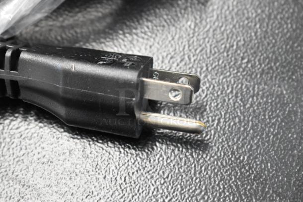 Close-up of a power plug for the Narvon 23BCWD8HT 8 GPH countertop water dispenser, showing prongs and black casing.