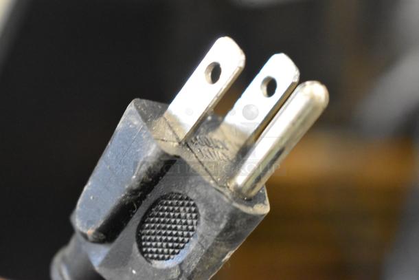 This image shows a close-up of the power plug of an appliance, likely for the Excellence EMM-2HC refrigerator.
