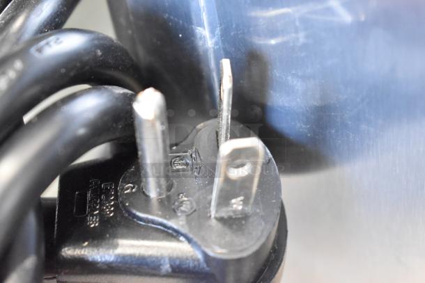 Close-up of a power plug for the Solwave SWA21T commercial microwave, showing prongs and cable.