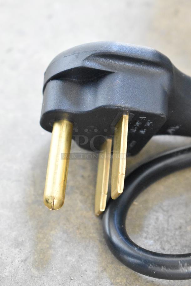 Close-up of a power plug for the Avantco 177SAL23M Salamander, showing three-pronged gold connectors.