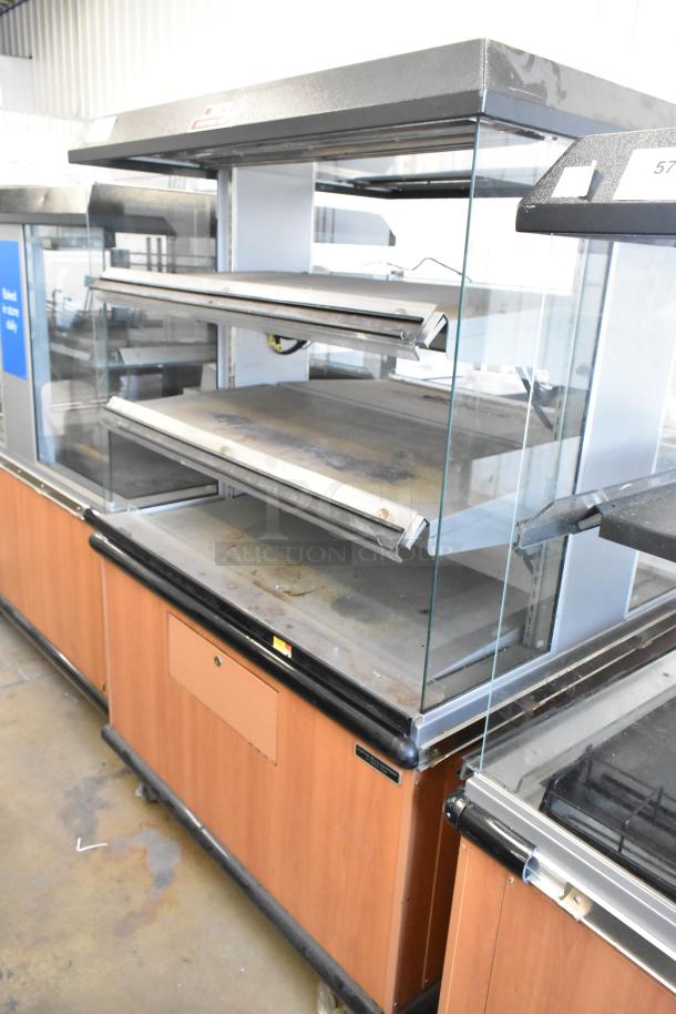 Custom Deli's Inc metal 2-tier warming display case with commercial casters. 120-208V, 1 phase. Signs of use, glass panels.