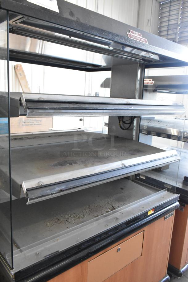 Custom Deli's Inc metal 2-tier warming display case. Features commercial casters. Uses 120-208V, 1 phase. Caution hot label.