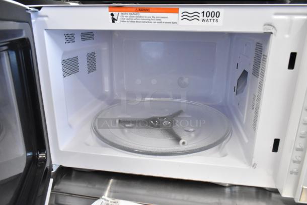 Hamilton Beach HB8436193153-02 microwave oven, 1000 watts, 120 volts, 1 phase. Features glass turntable and warning label.