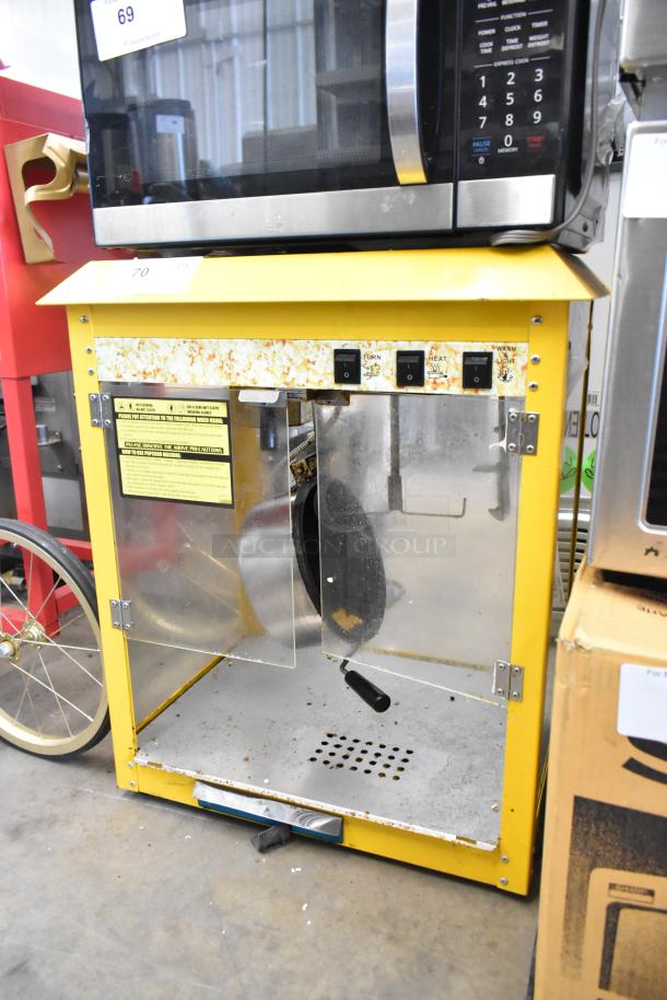 Metal commercial countertop popcorn machine, yellow, with control switches and glass doors. 115 volts, 1 phase. Used condition.
