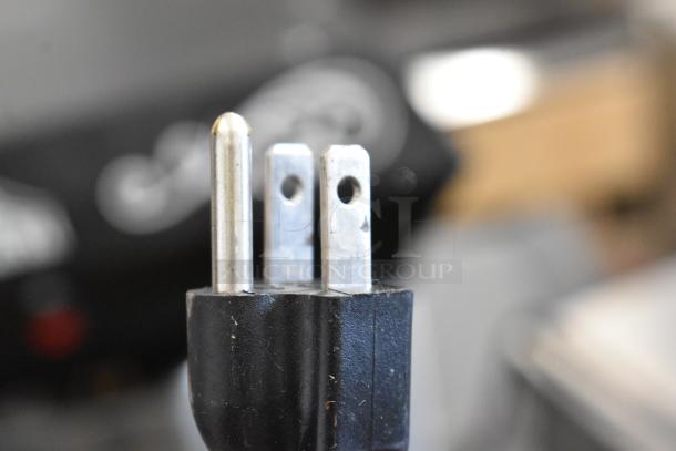 Close-up of a black electrical plug with three prongs for the Olde Midway P600 Popcorn Machine, 120 Volts, 1 Phase.