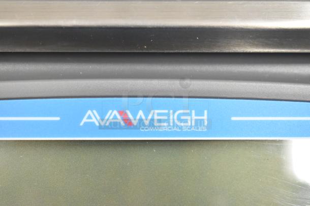 Brand new AvaWeigh 334PCN20 20 lb. portion scale, minor cosmetic scratches, legal for trade, blue logo visible.