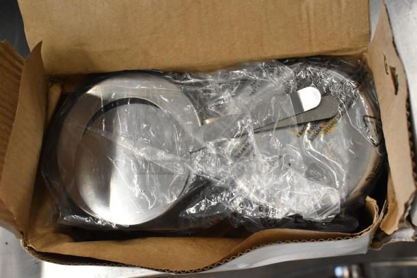 Brand new stainless steel roll top chafing dish in original packaging. Slight scratches noted. Includes handle accessory.