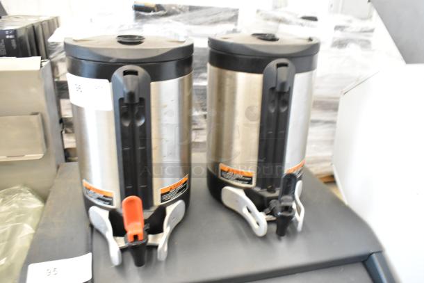 Two Bunn SH SERVER stainless steel coffee servers. Black lids and handles, minor wear visible. Ideal for high-volume use.