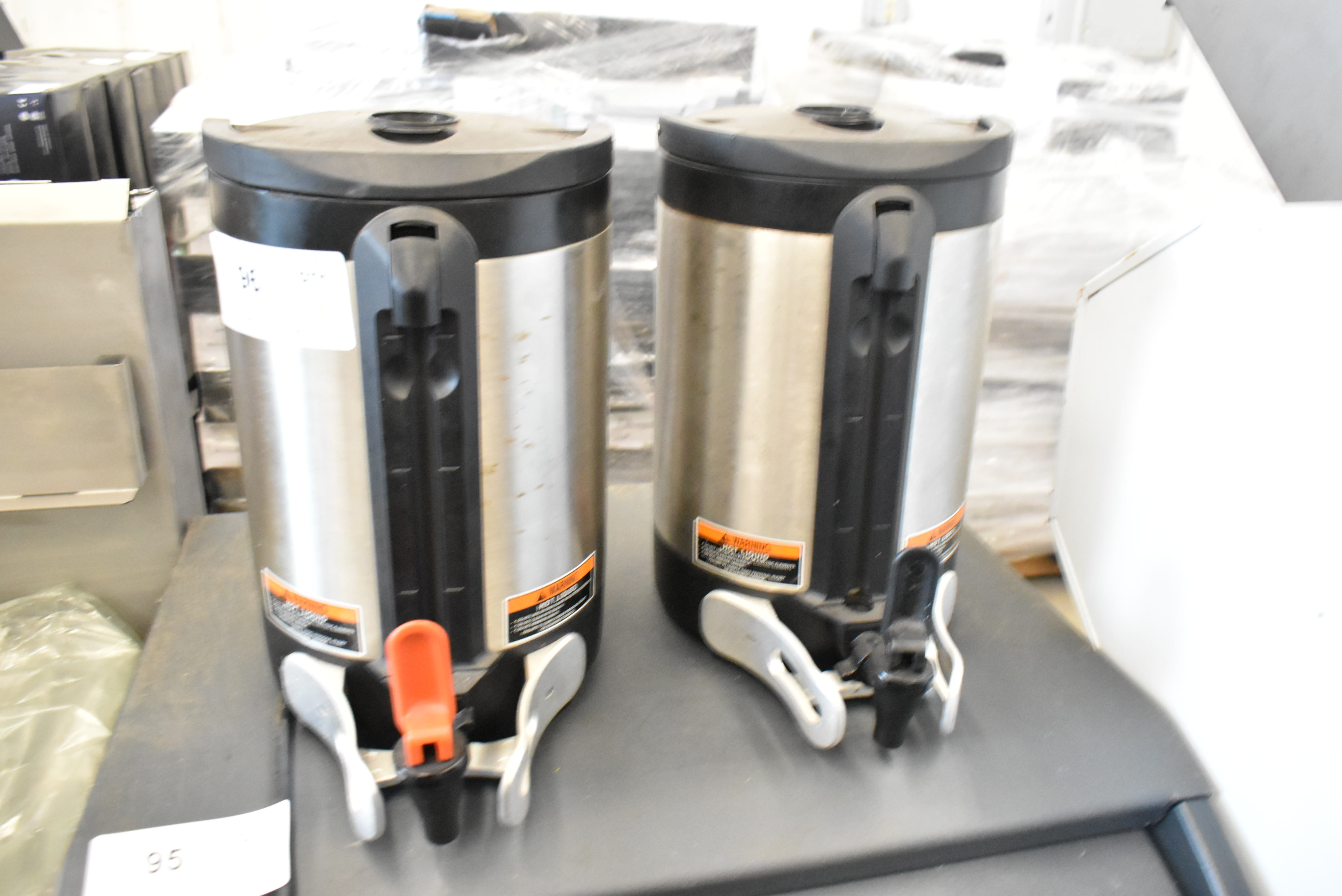 Two satellite coffee dispensers with spigots for remote serving